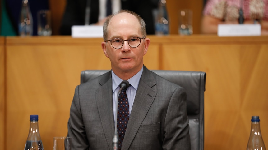 Chief Medical Officer Paul Kelly sitting in a committee room during a press conference