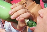 A youth takes part in a beer drinking competition