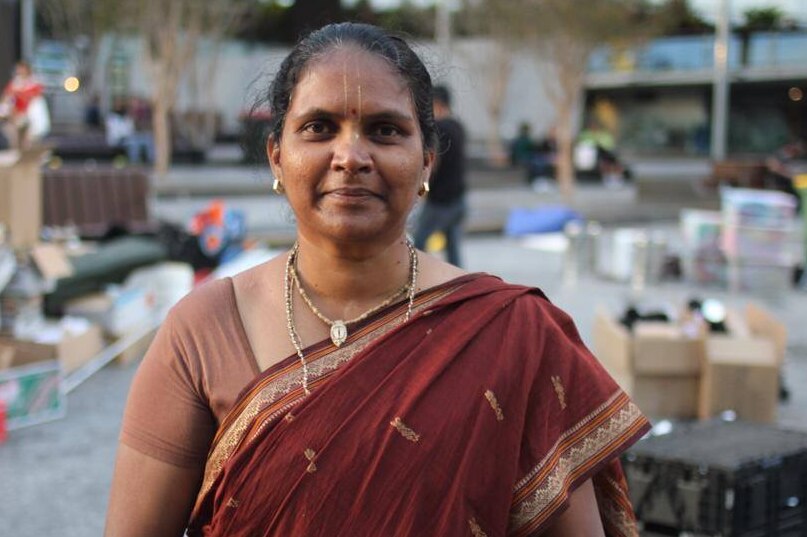 A woman dressed in traditional Indian clothing stands in King George Square, Brisbane.