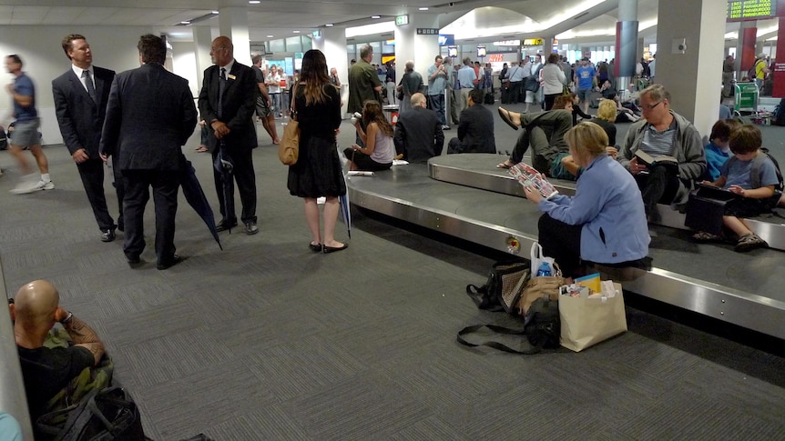 Travellers sit throughout Perth Airport after lightning strikes forced ground staff to stop working.