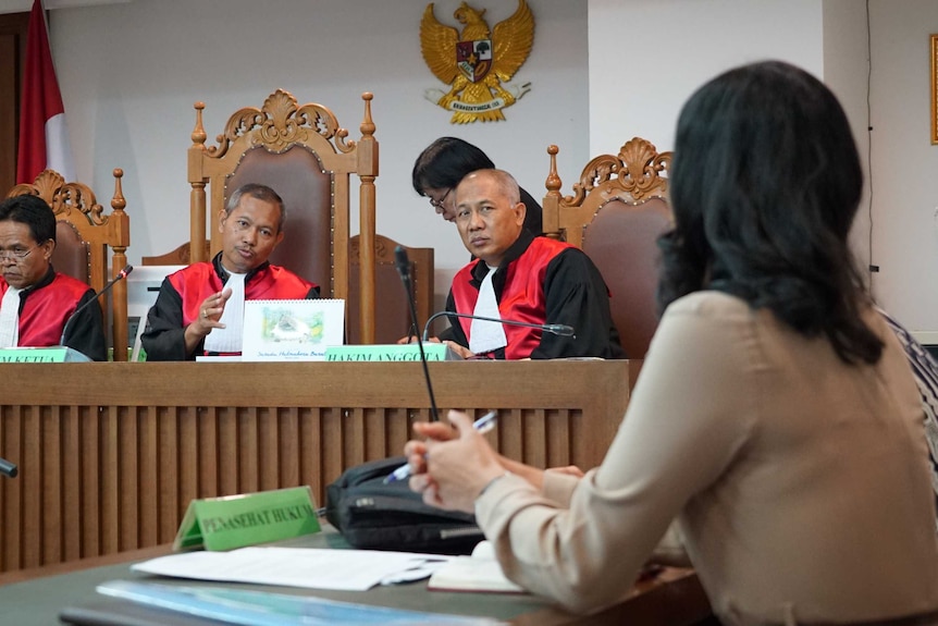 Judges in an Indonesian court speak to a lawyer from the bench.