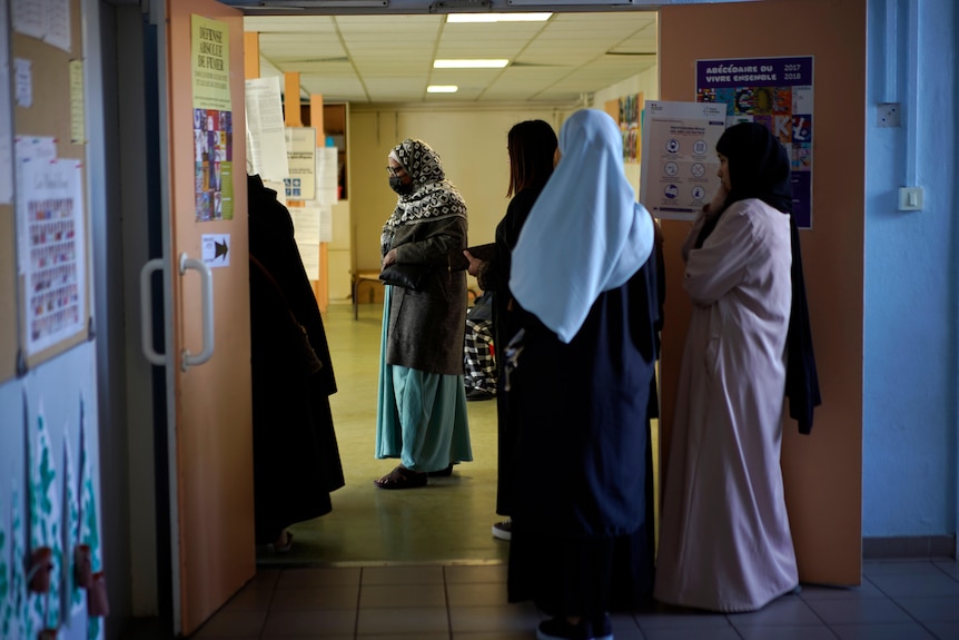 Women wait in line before french election