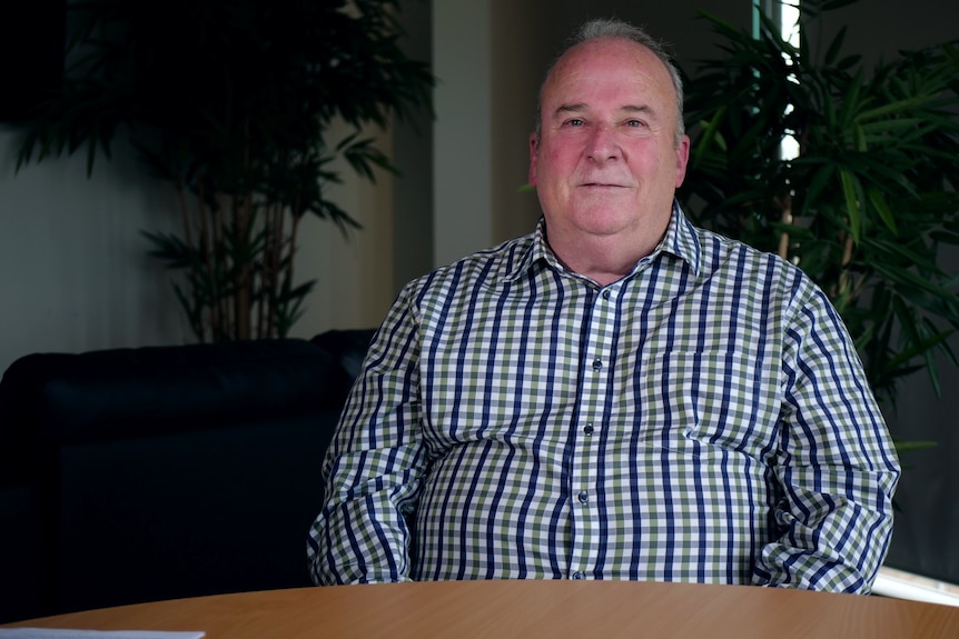 Eric Coulter wearing a checked shirt and looking at the camera.