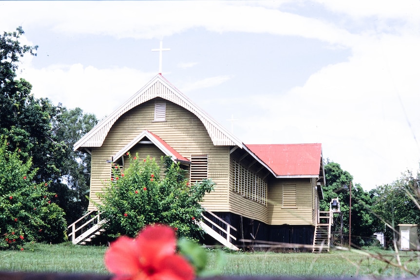 a colourful picture of a wooden church positioned on green grass