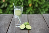 Glass with rosemary, lime and a fizzy drink