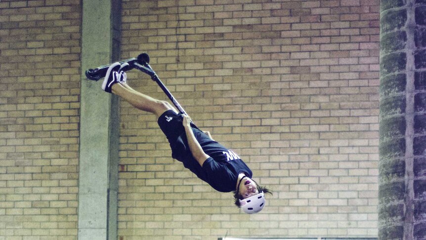 Australian champ Dylan Sinclair flips in the air at an indoor skate park