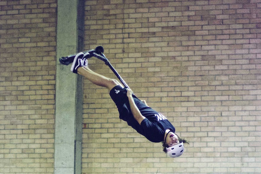 Australian champ Dylan Sinclair flips in the air at an indoor skate park