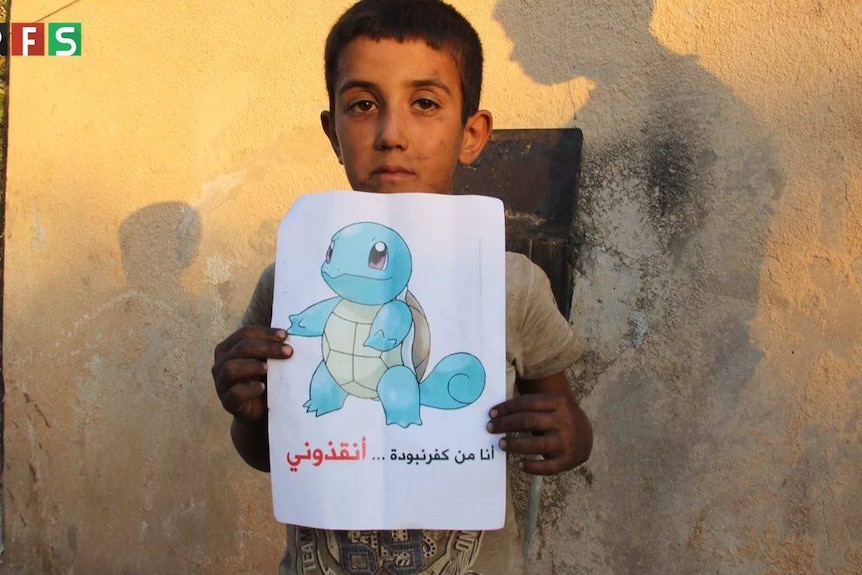 Syrian boy holds up picture of Squirtle