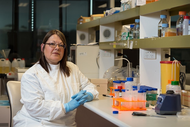 Dr Trudi Collet sitting at a laboratory at QUT's Institute of Health and Biomedical Innovation in Brisbane.