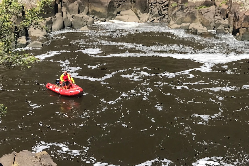A small rescue dinghy on choppy water at a gorge.