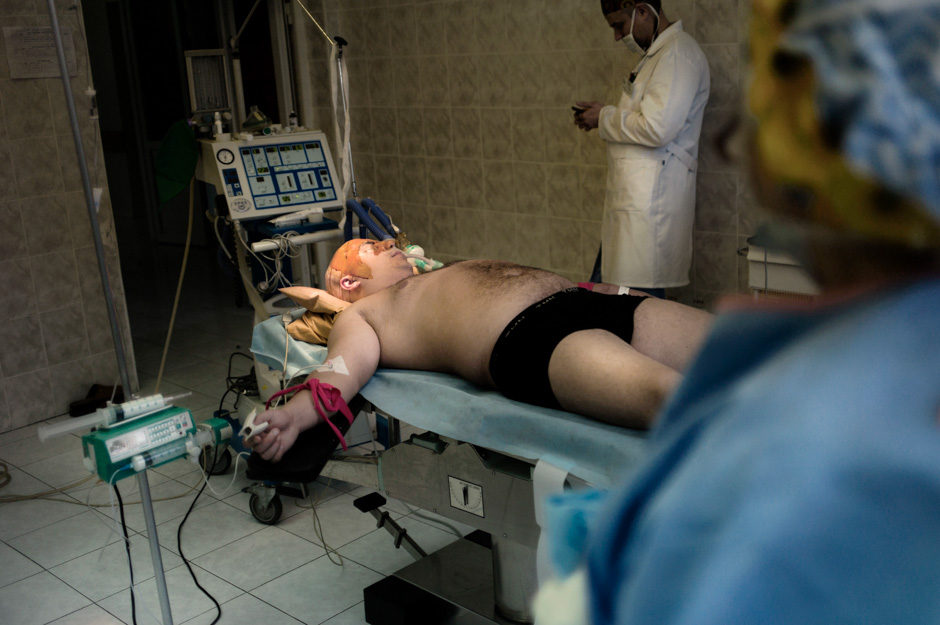 A wounded soldier lies anaesthetised, ready for surgeons to perform reconstructive cranial surgery.