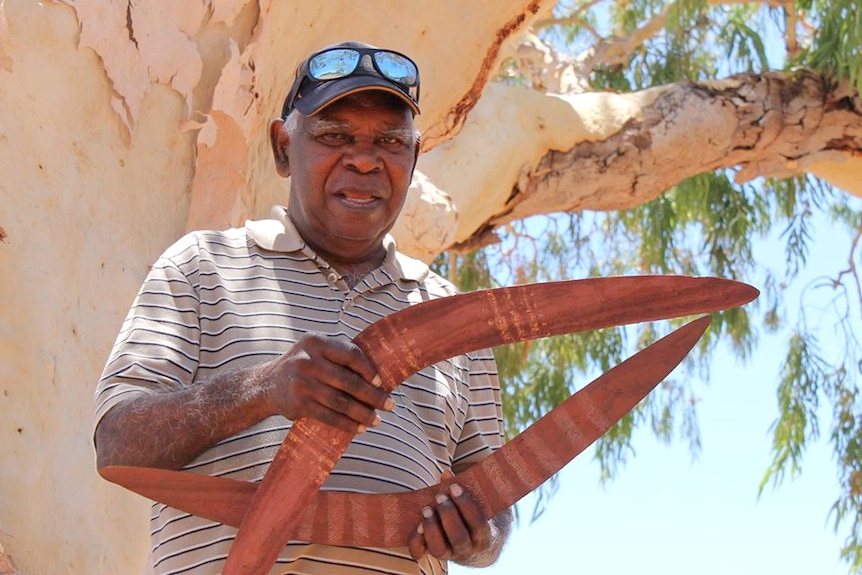 An Aboriginal man with boomerangs.