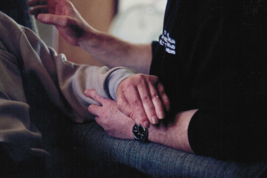 Two hands, touching during rehab.
