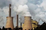 Huge power plants with chimney blowing smoke into the air.