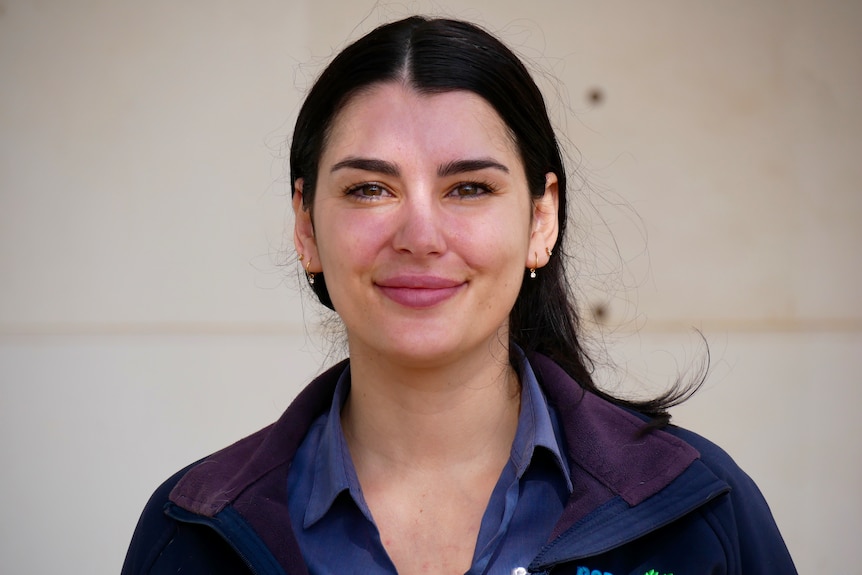 A white woman with dark hair wearing an RSPCA jacket smiling. 