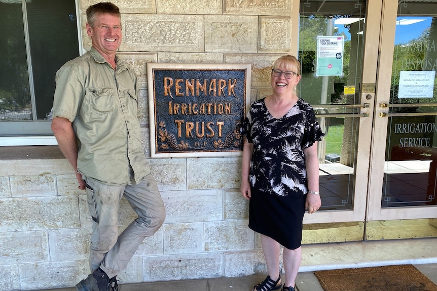 A man and a woman standing in front of a sign at the Renmark Irrigation trust.