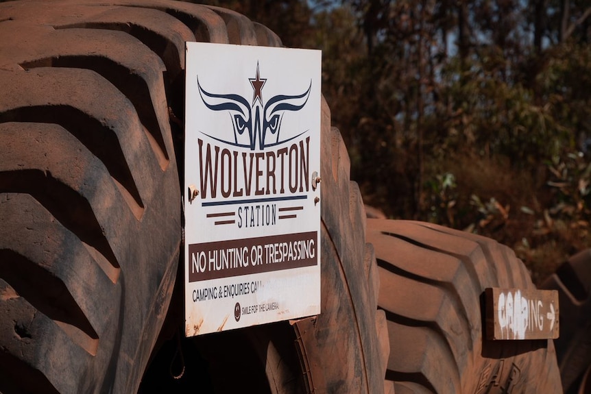 Tractor tyres line the road with a sign 