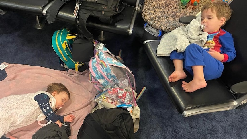 Two children sleeping in an airport terminal.