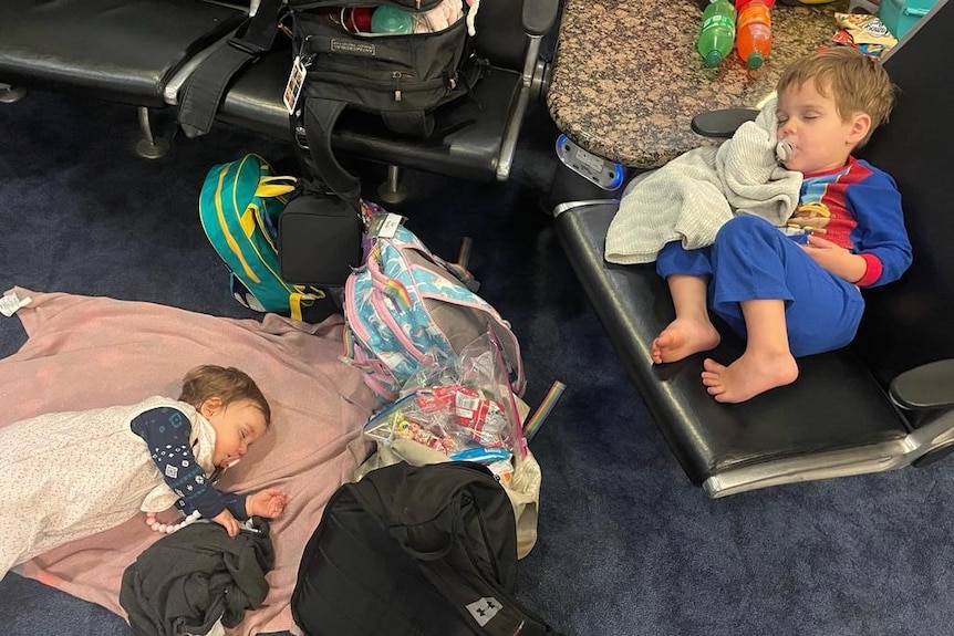 Two children sleep in an airport terminal.