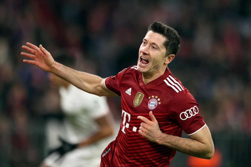 Robert Lewandowski points to his chest and opens his mouth with his other arm out to the side