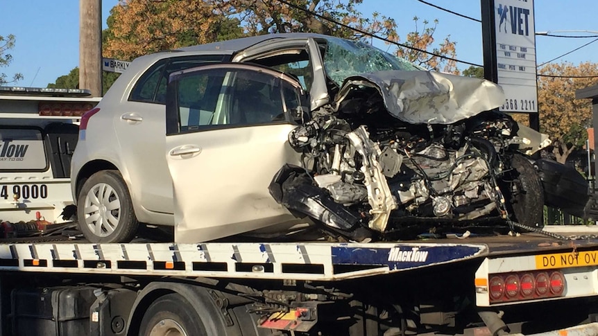 The badly damaged car belonging to the dead woman on the back of a tow truck.