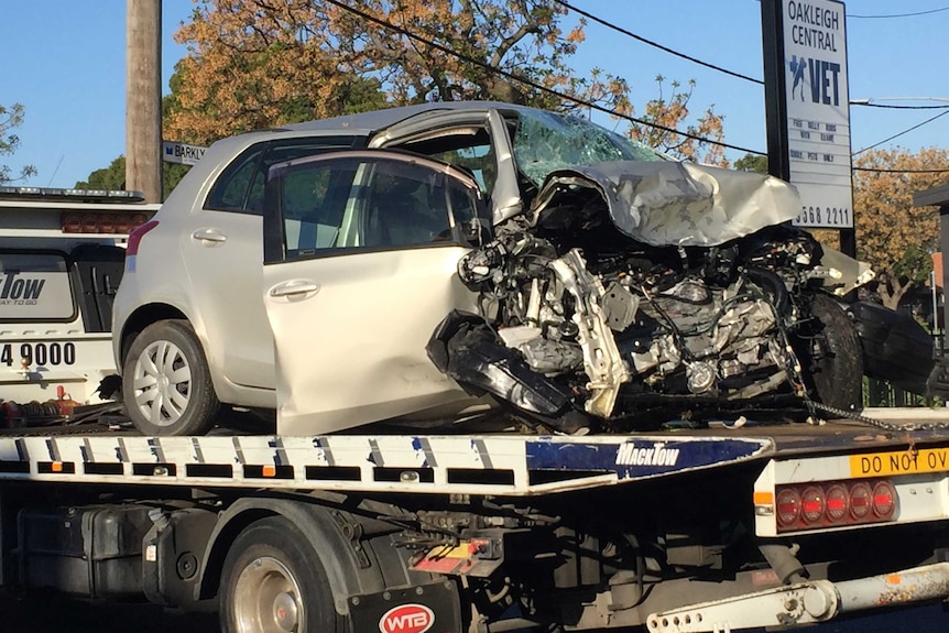 The badly damaged car belonging to the dead woman on the back of a tow truck.