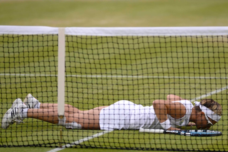 Kirsten Flipkens kisses the ground after win.