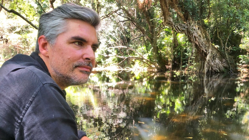 A man is overlooking a rainforest creek near his family home which has inspired a photographic exhibition.