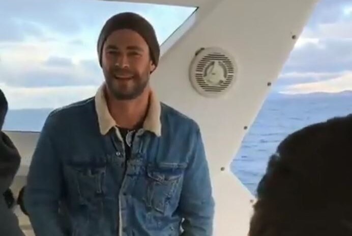 Movie star Chris Hemsworth on a boat heading to watch the Cape Fear big wave competition, Tasmania.
