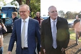 A composite image of Anthony Albanese and Scott Morrison each walking in a crowd of photographers