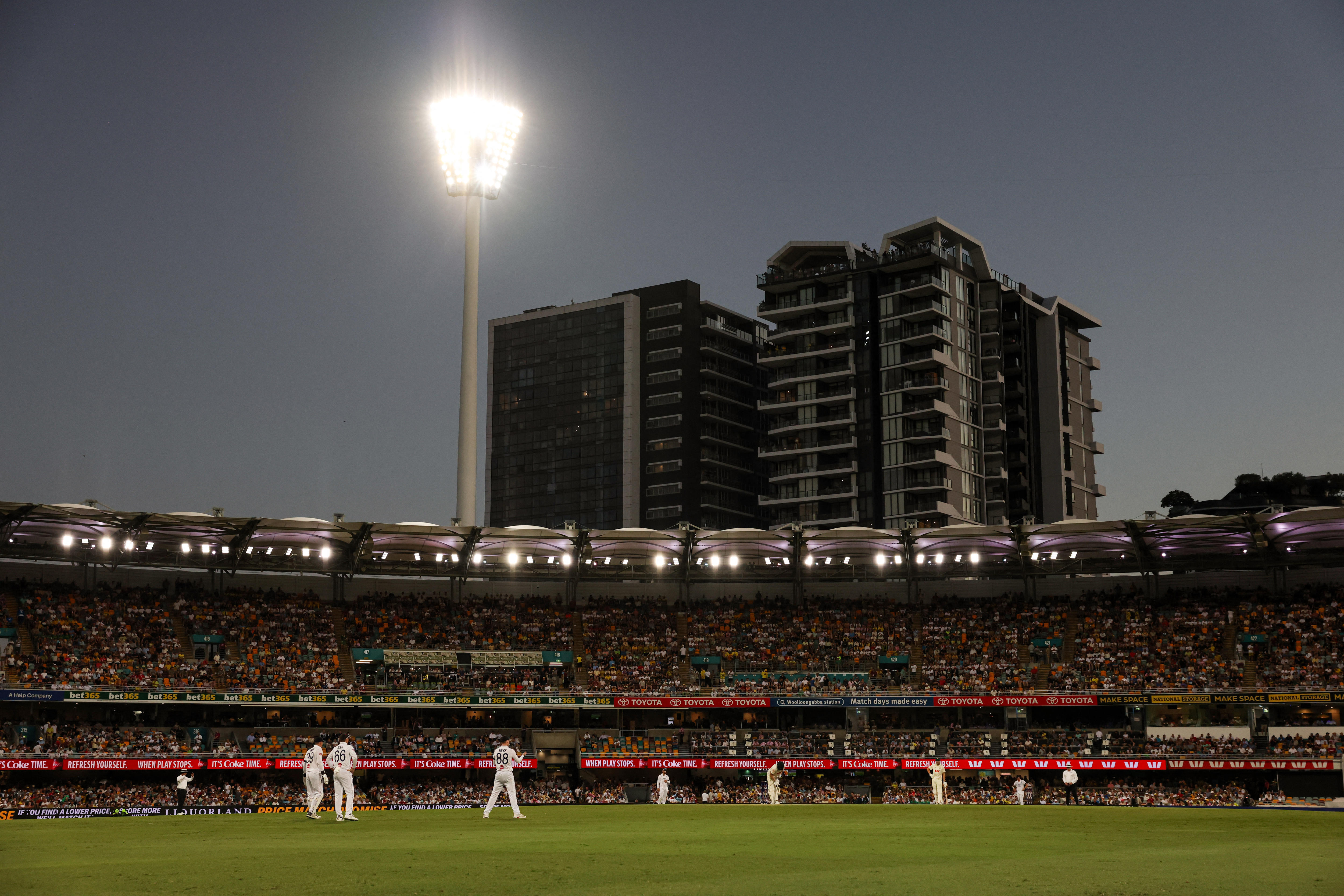 a zoomed out image of cricketers on the pitch at the gabba in 2025 test match