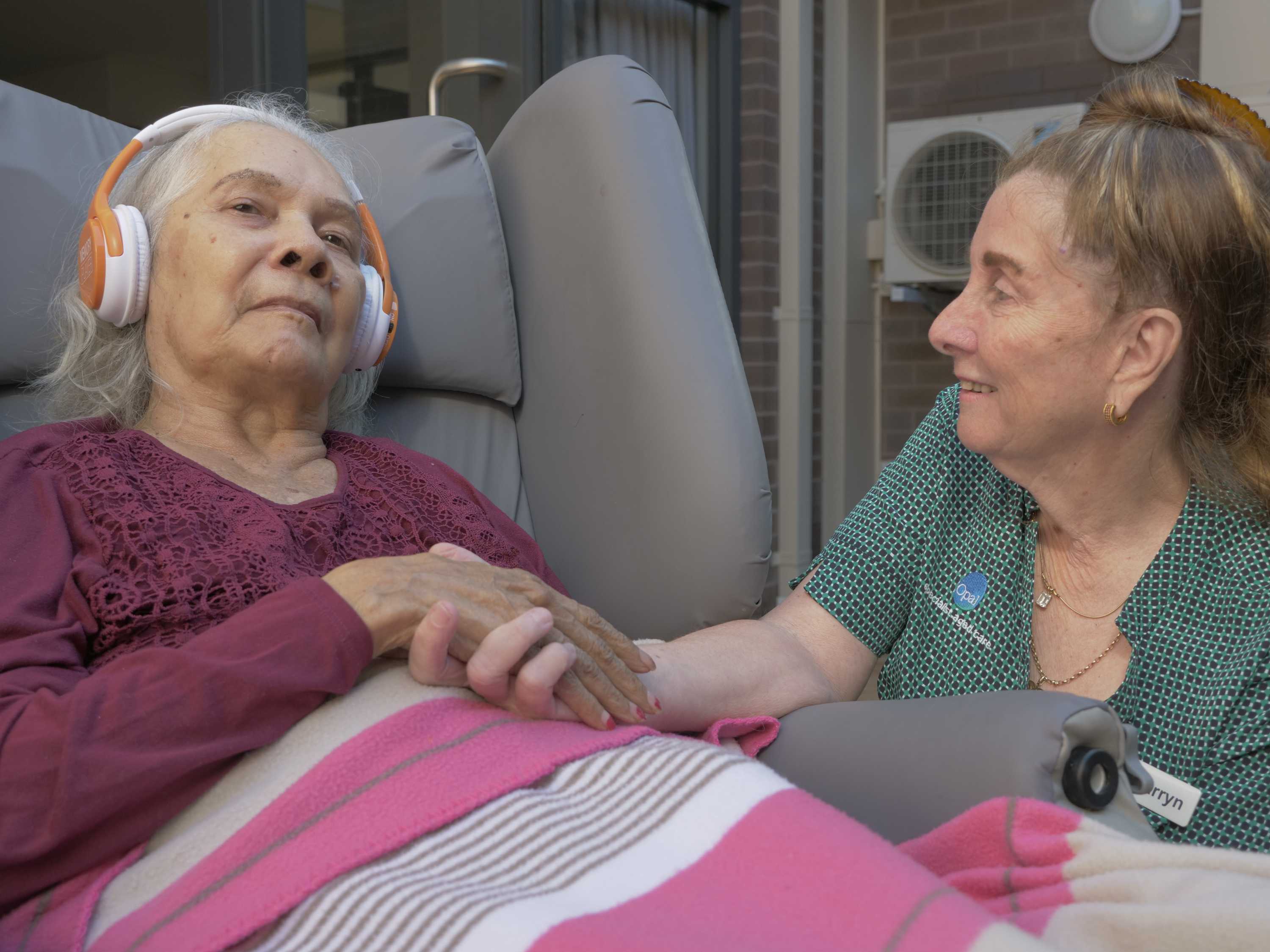 Opal Care resident June listens to her music, while manager Carryn Herman watches on.