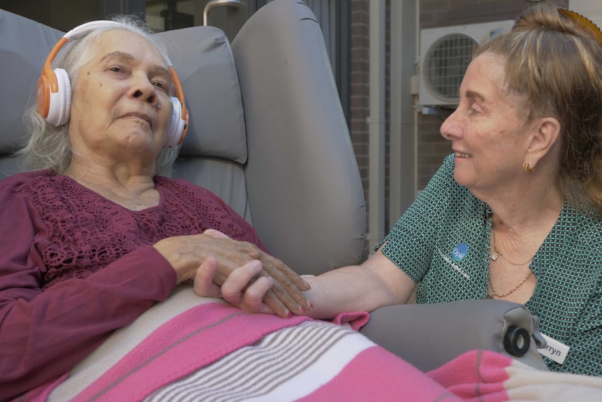 Opal Care resident June listens to her music, while manager Carryn Herman watches on.