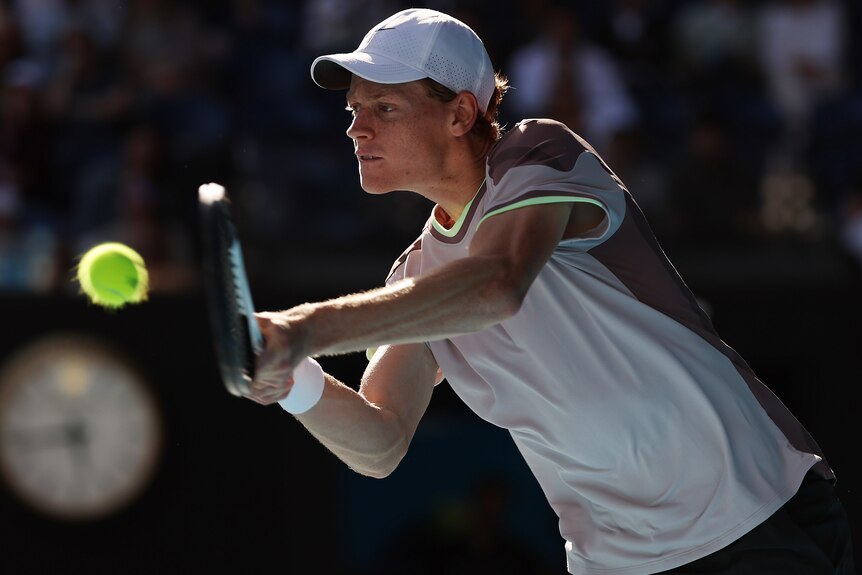 Jannik Sinner plays a double-fisted backhand against Novak Djokovic at the 2024 Australian Open.