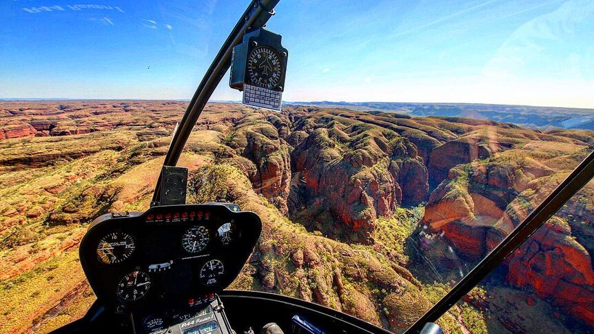 The dash of a helicopter as it flies over the Bungle Bungle rock formations.
