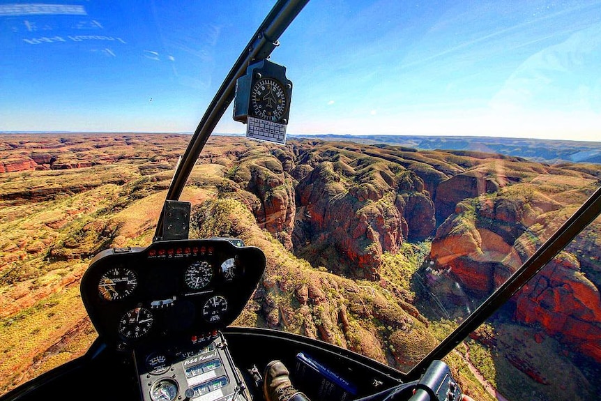 The dash of a helicopter as it flies over the Bungle Bungle rock formations.