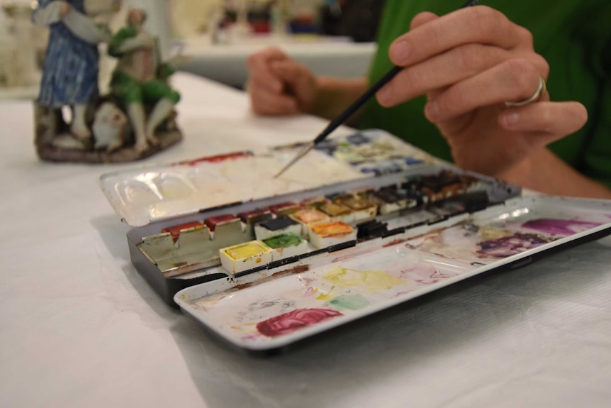 Close-up of Trude Ellingsen's hands, paintbrush, paints