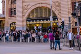 People cross the road at Flinders St station.