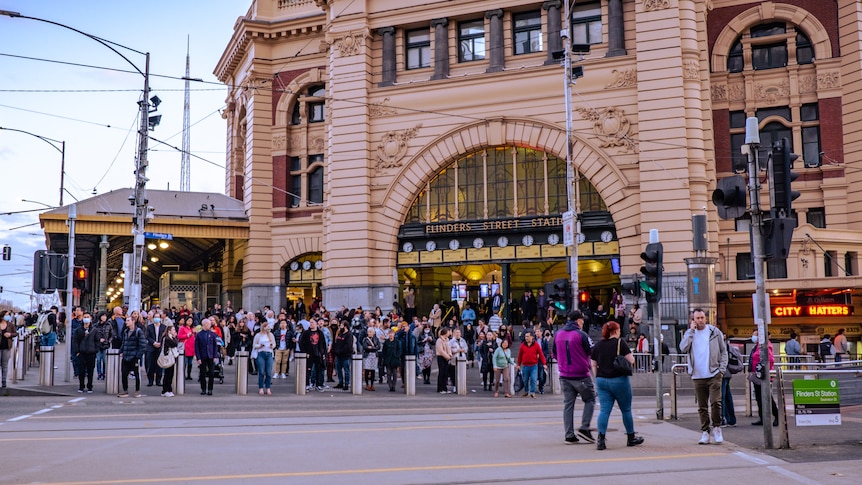 People cross the road at Flinders St station.