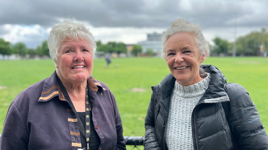 Richmond residents Lyn Payne and Victoria Chipperfield stand, smiling and in warm jackets, in a park on a cloudy day.