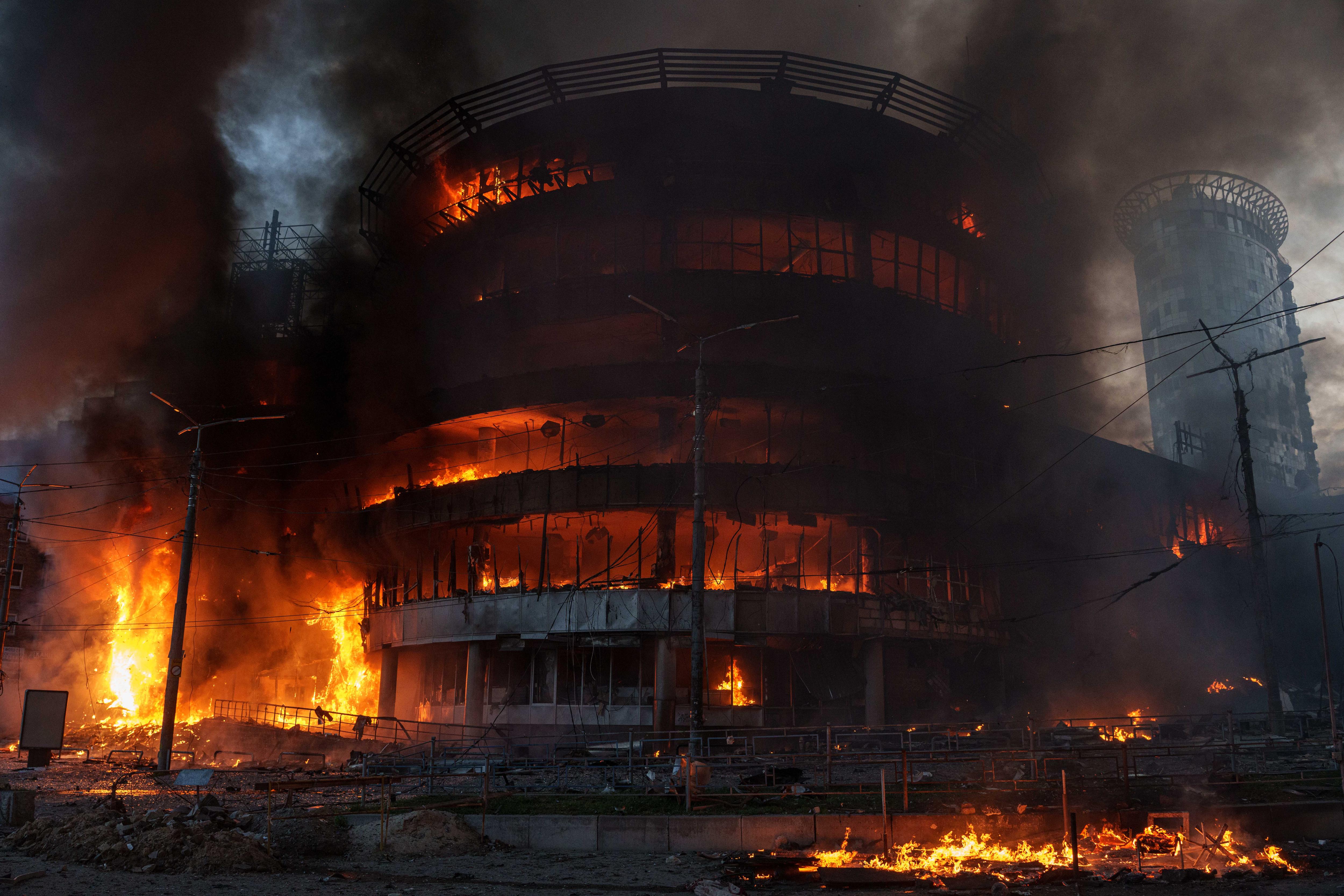 A circular approximately four-storey building up in flames. 