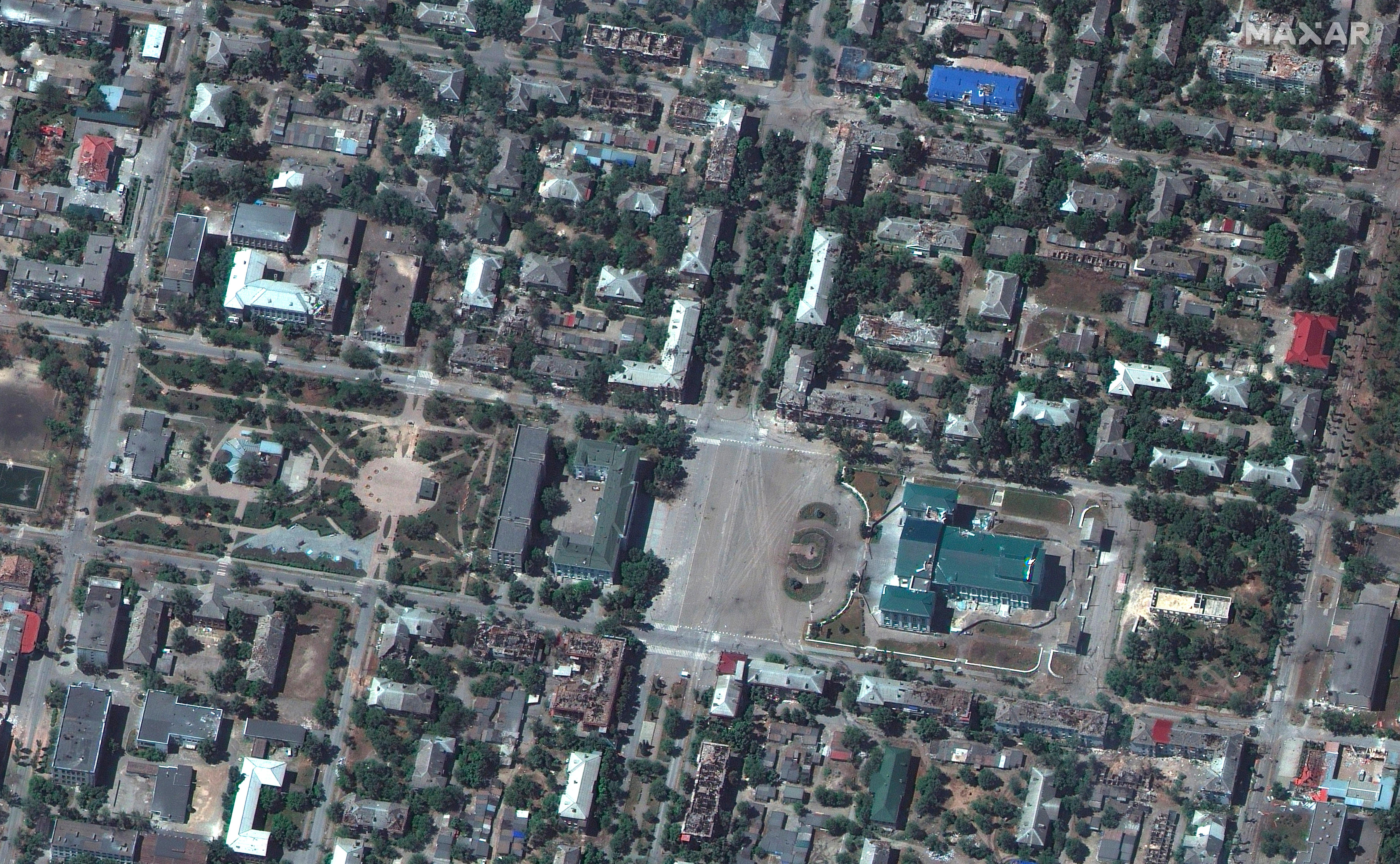 A satellite image of damaged buildings throughout a town. 