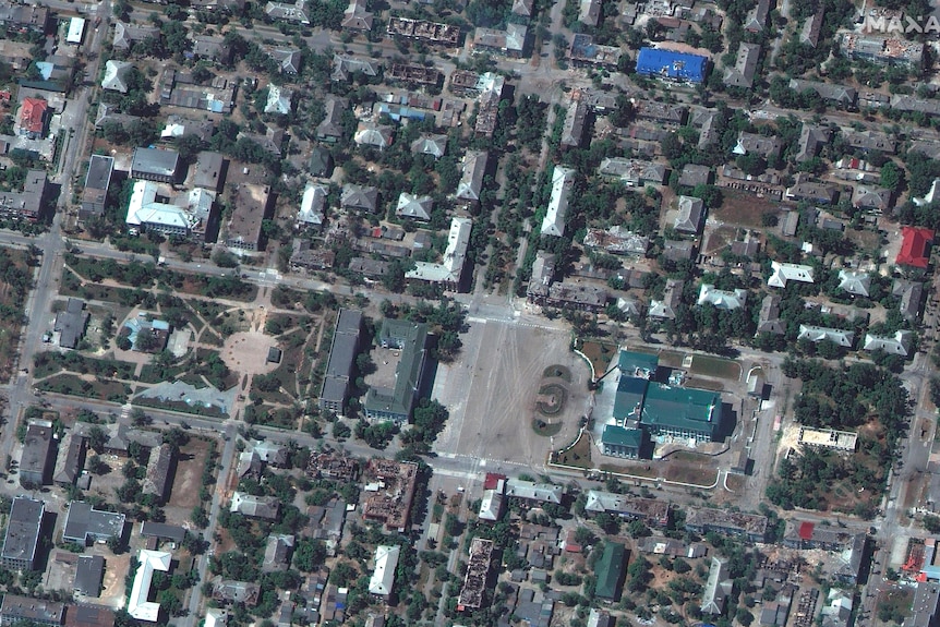 A satellite image of damaged buildings throughout a town. 