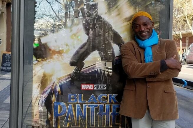 Brian Stelfreeze standing in front of a black panther poster.