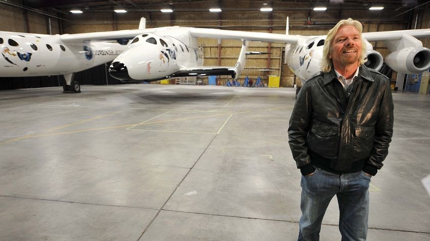 Sir Richard Branson poses for photos at the official unveiling of Virgin Galactic's SpaceShipTwo