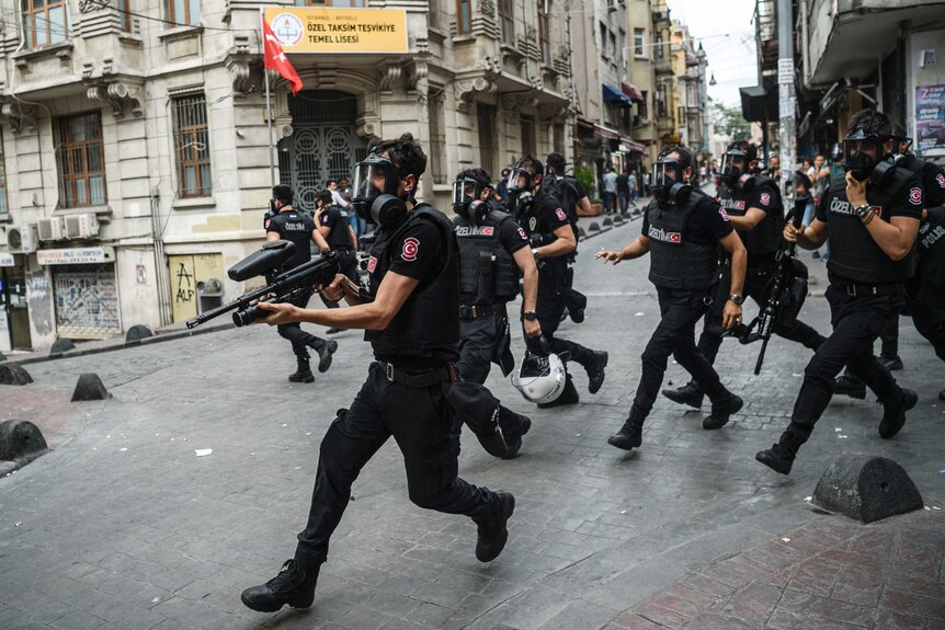 Turkish anti riot police officers running on a street.