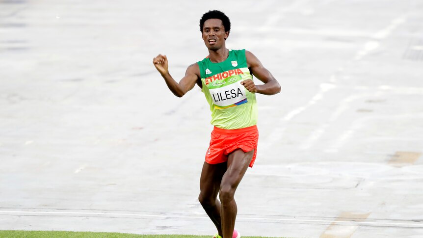 Silver medallist Feyisa Lilesa celebrates after crossing the marathon finish line.
