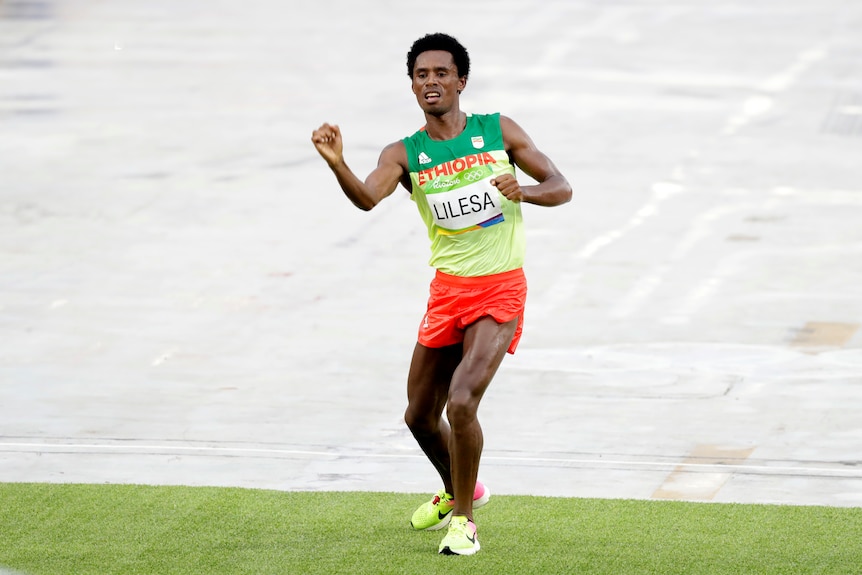 Silver medallist Feyisa Lilesa celebrates after crossing the marathon finish line.