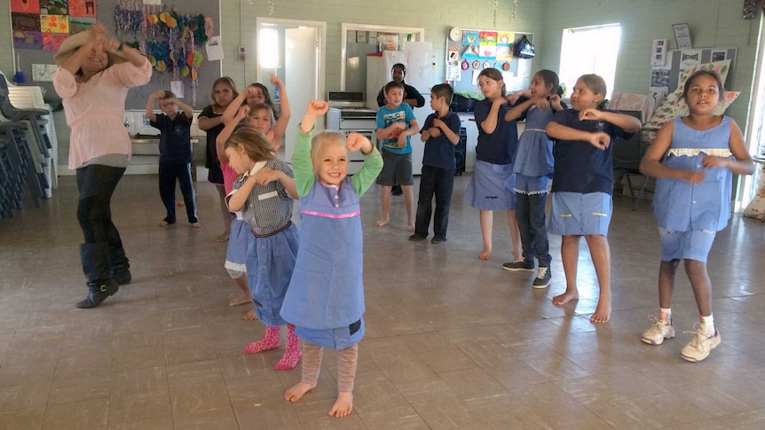 Children at KidsZone in Meekatharra put on a dance performance for local police, while wearing the recycled uniforms.