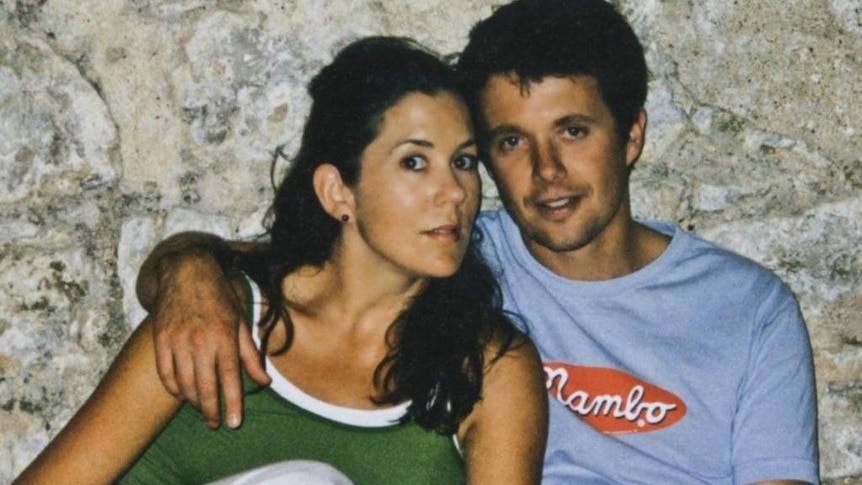 A man puts his arm around the shoulders of a young woman, both of them with dark hair.
